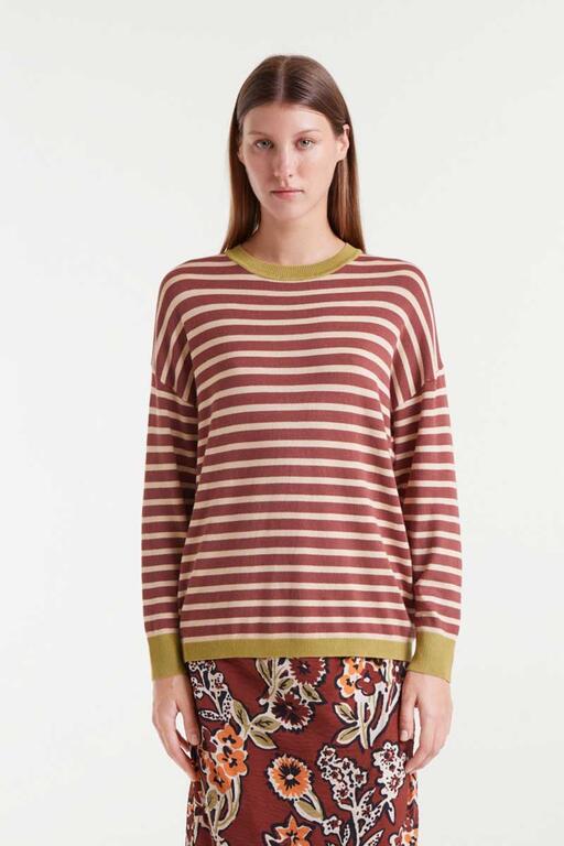 Woman wearing a striped sweater with a plain background