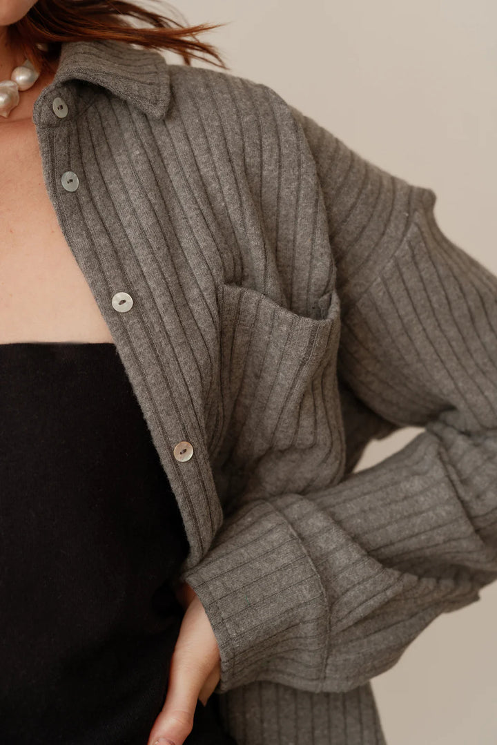 A detail image of the buttons and shoulder of the Sweater Rib Button Down in Charcoal Grey on a female model