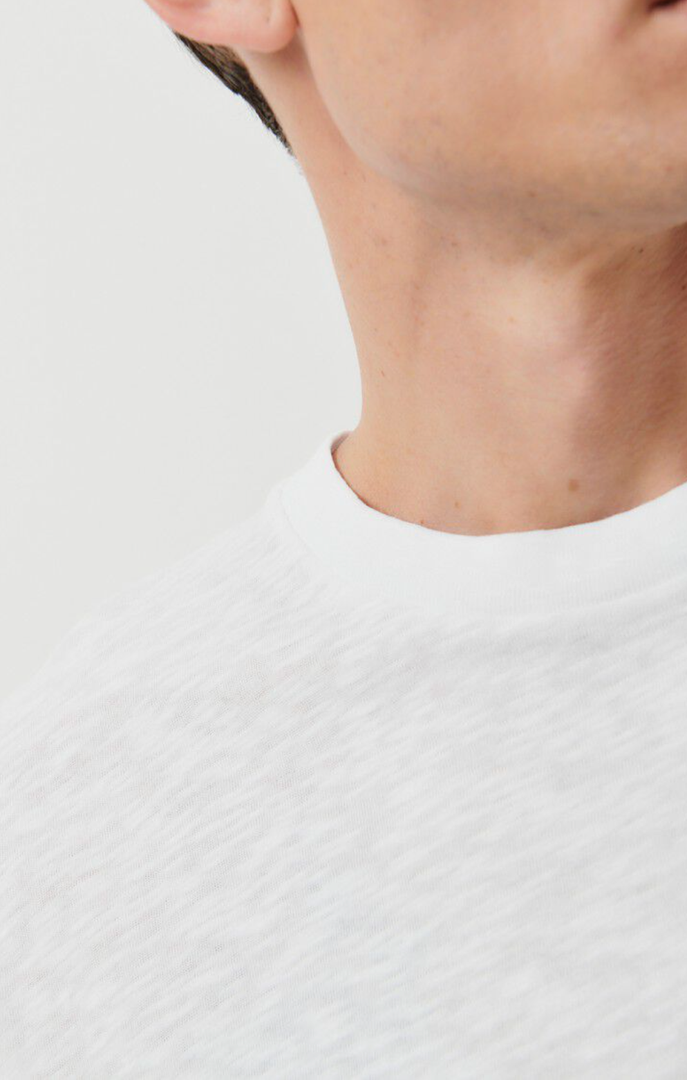 a very close up neckline detail image of the Bysapick T-Shirt in white on a male model 