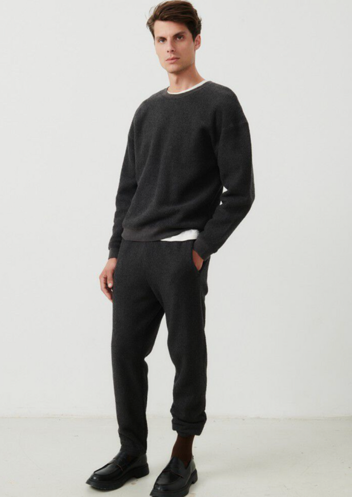 Full body image of a male model standing at an angle while wearing the Bobypark Joggers in anthracite styled with the matching crewneck