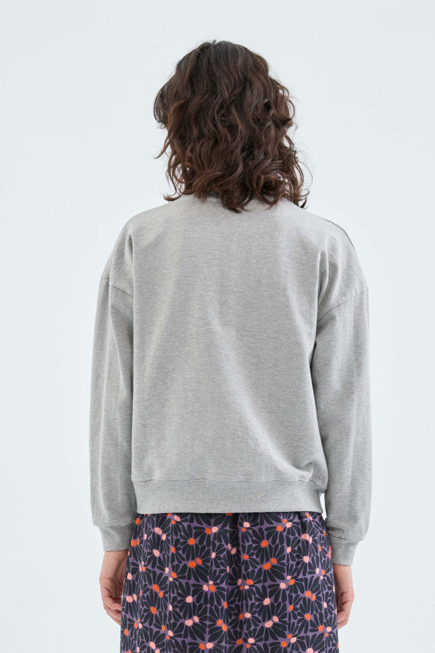 A medium close image showing the back of a female model wearing the Sweatshirt with Seam Detail