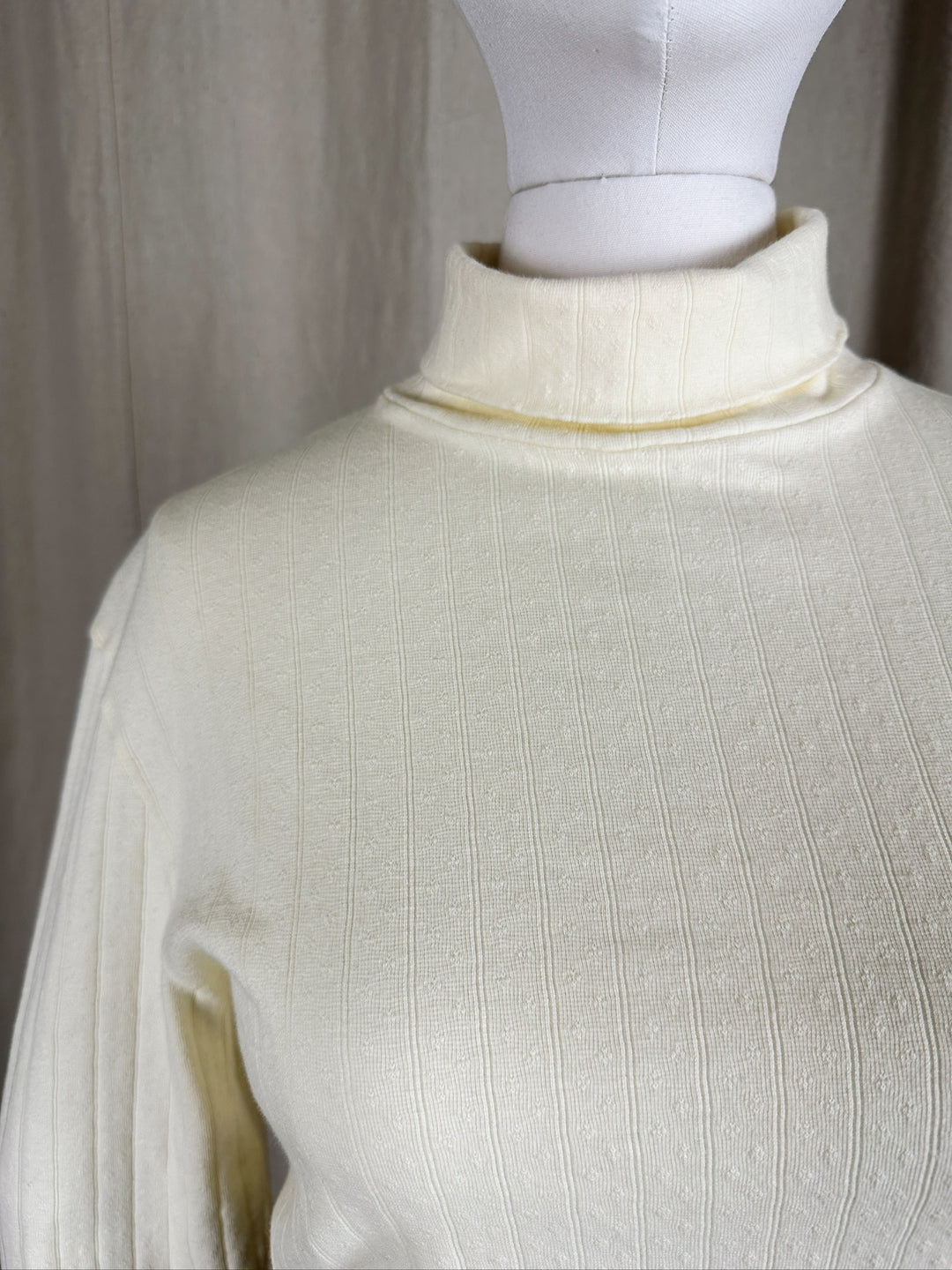 Close up detail image of the neckline of the Pointelle Turtleneck on a mannequin