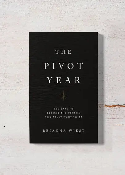 Book titled 'The Pivot Year' by Brianna Wiest on a light wooden surface