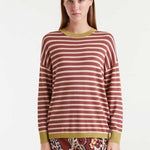 Woman wearing a striped sweater with a plain background