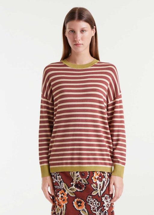 Woman wearing a striped sweater with a plain background