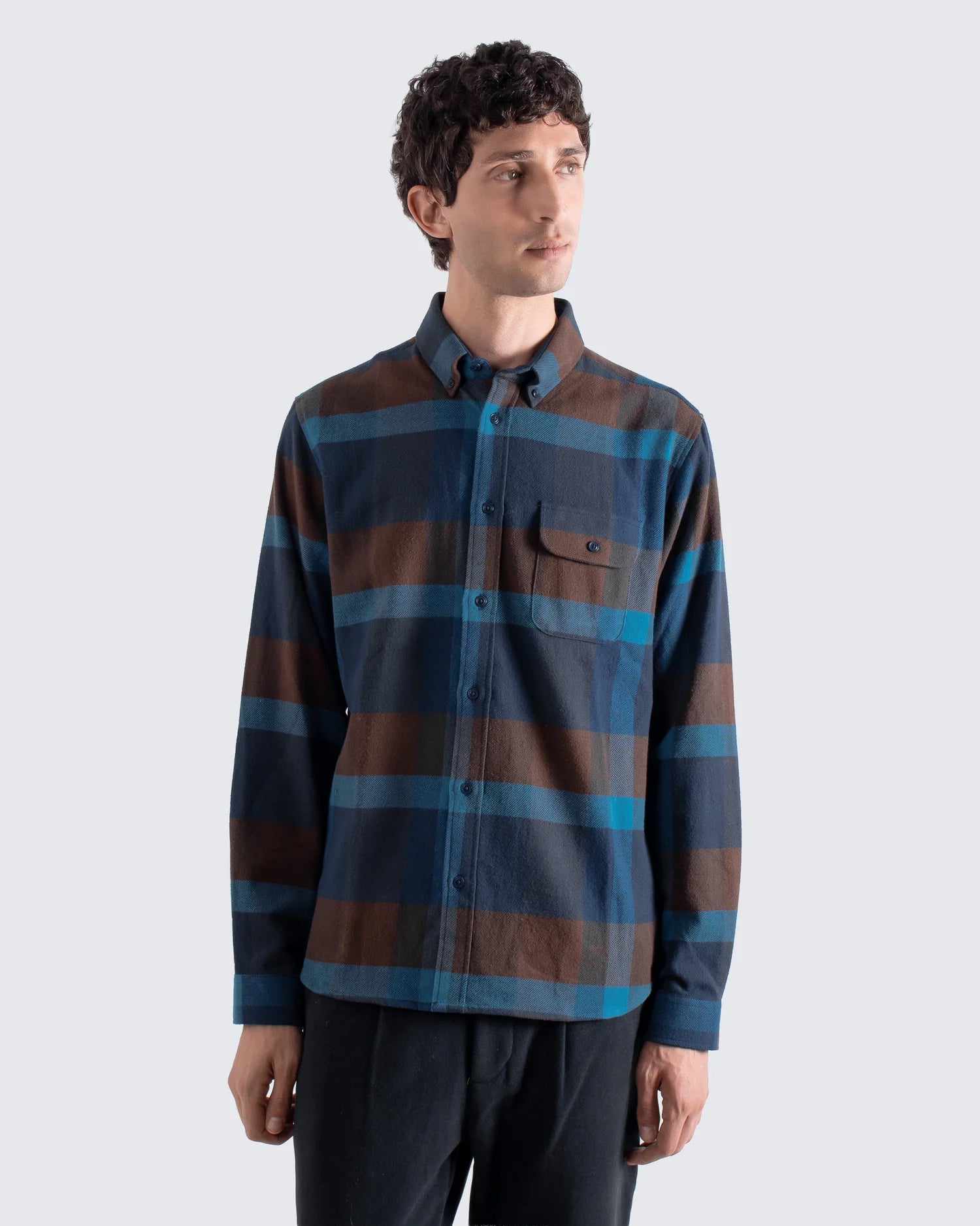 Man wearing a striped shirt with blue and brown colors on a white background