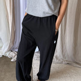 Person wearing black pants and a grey tee shirt in an indoor setting