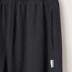 Close up of knit black joggers on a hanger.