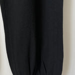 Close up of bottom of leg of black knit joggers.