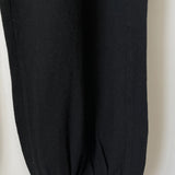 Close up of bottom of leg of black knit joggers.