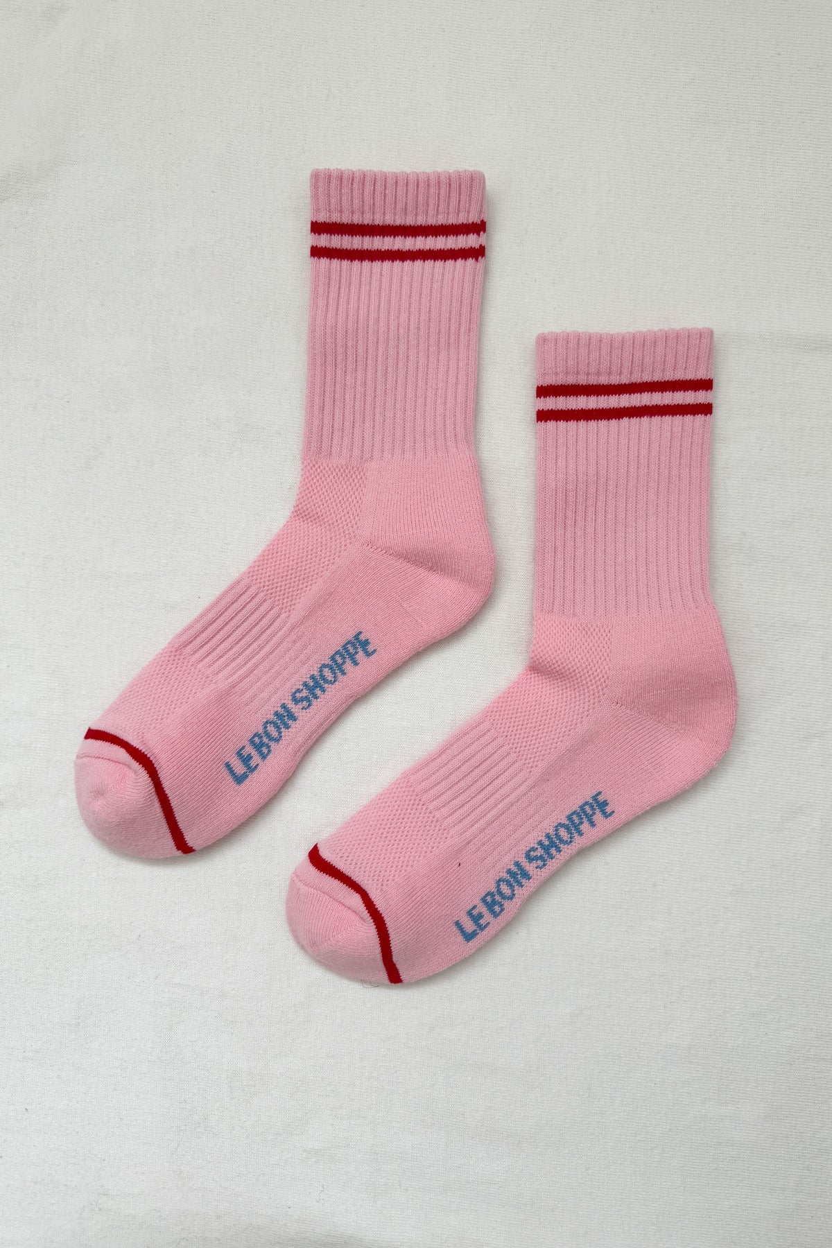 Pink socks with red stripes on a white background.