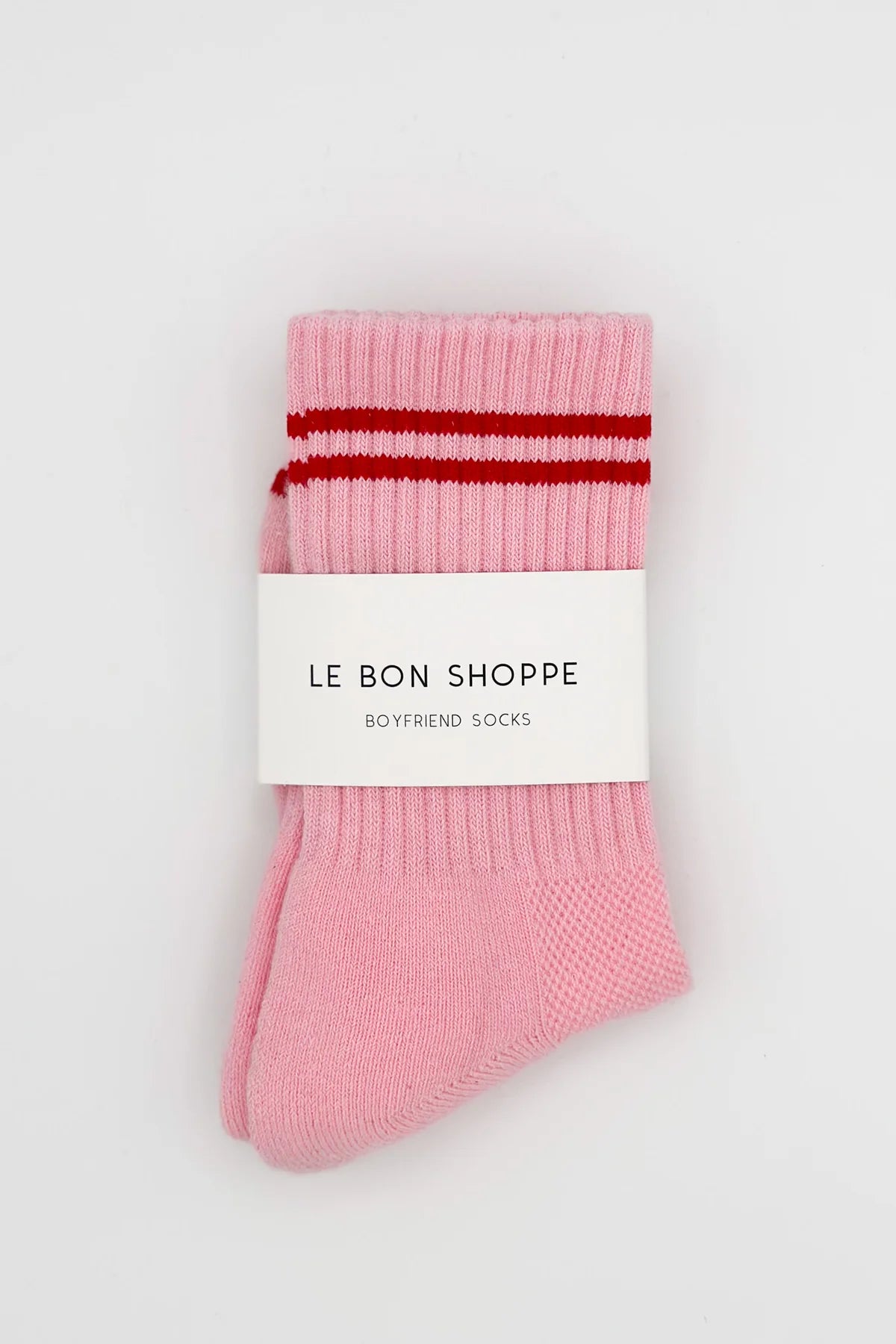 Pink socks with red stripes in Le Bon Shoppe packaging.