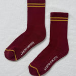 Maroon socks with gold stripes on a white bavkground.