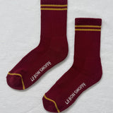 Maroon socks with gold stripes on a white bavkground.