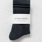 Pair of gray socks with a label on a light gray background