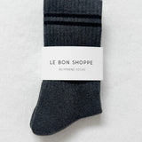 Pair of gray socks with a label on a light gray background