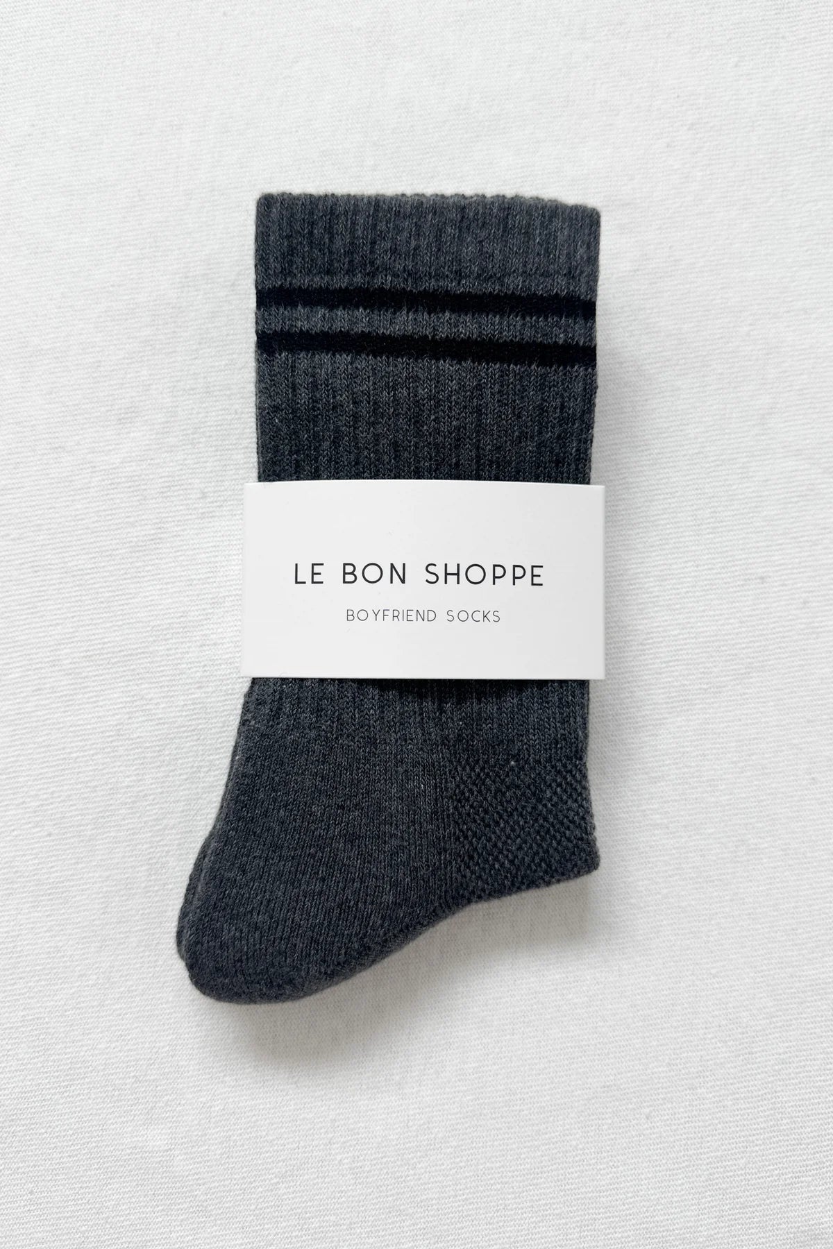Pair of gray socks with a label on a light gray background