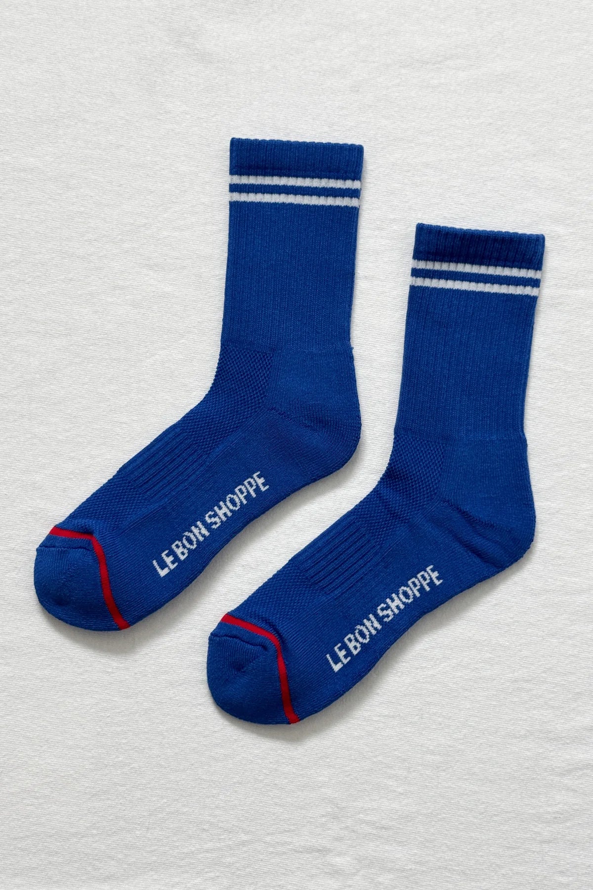 A pair of blue socks with white stripes on a white background.