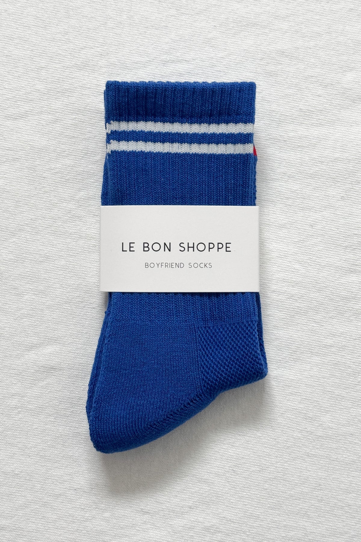 A pair of blue socks with white stripes on a white background.