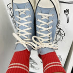Blue high-top sneakers with white laces worn with red socks against a white background with black line art.