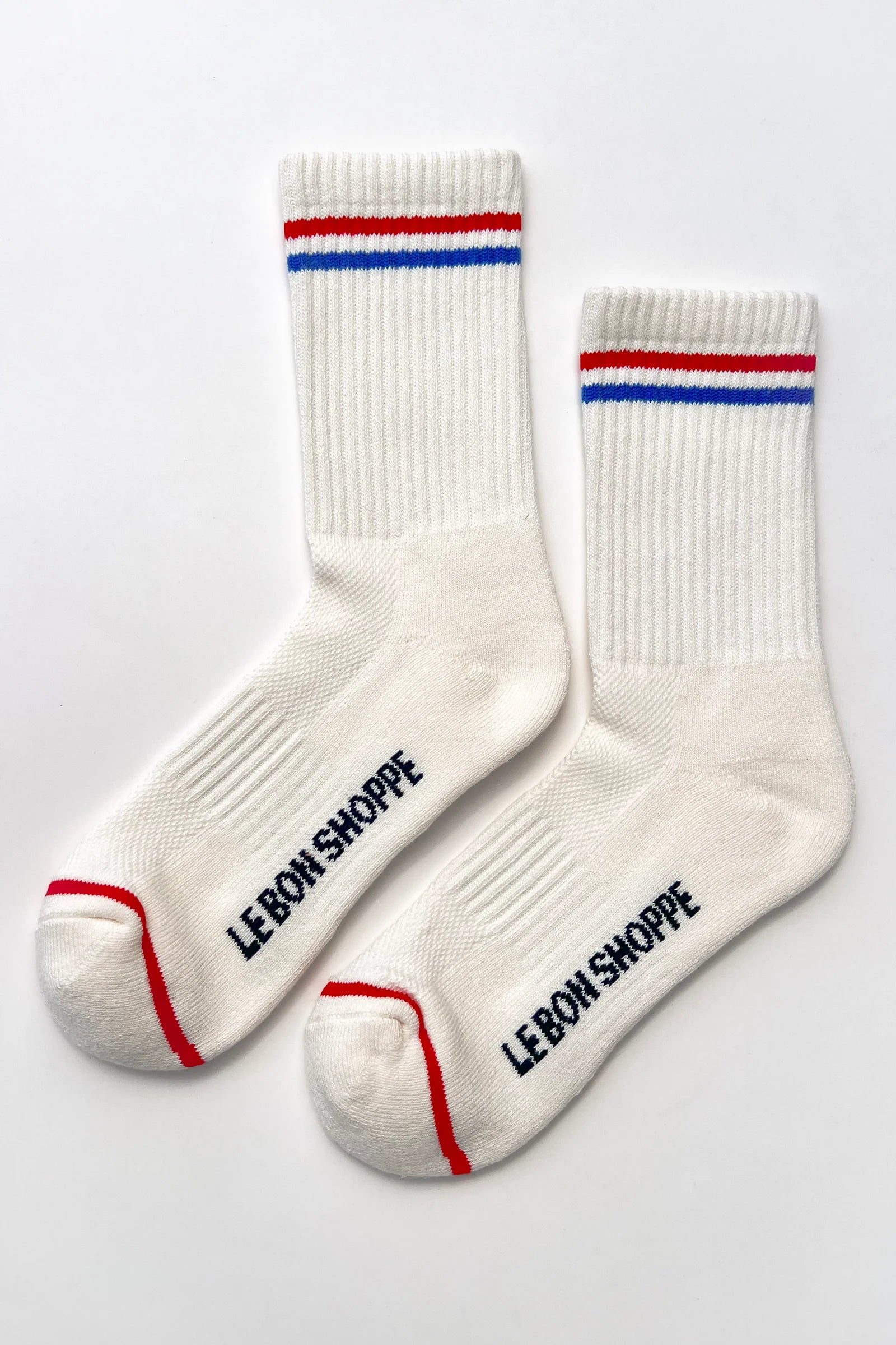 White socks with red and blue stripes and 'LEBON SHOPPE' branding on a light gray background