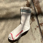 White socks with green stripes and red stripe along the toe and Le Bon Shoppe branding.