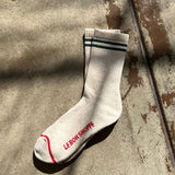 White socks with green stripes and red stripe along the toe and Le Bon Shoppe branding.