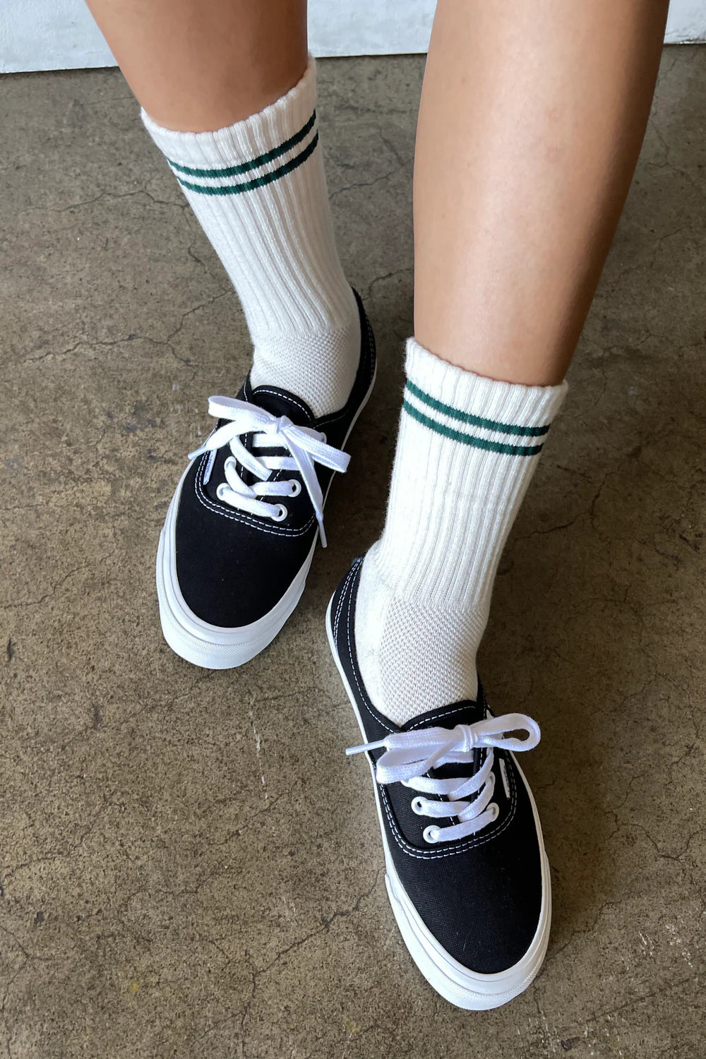 White socks with green stripes worn with black sneakers.