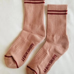 Pink socks with red stripes on white background.