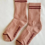 Pink socks with red stripes on white background.