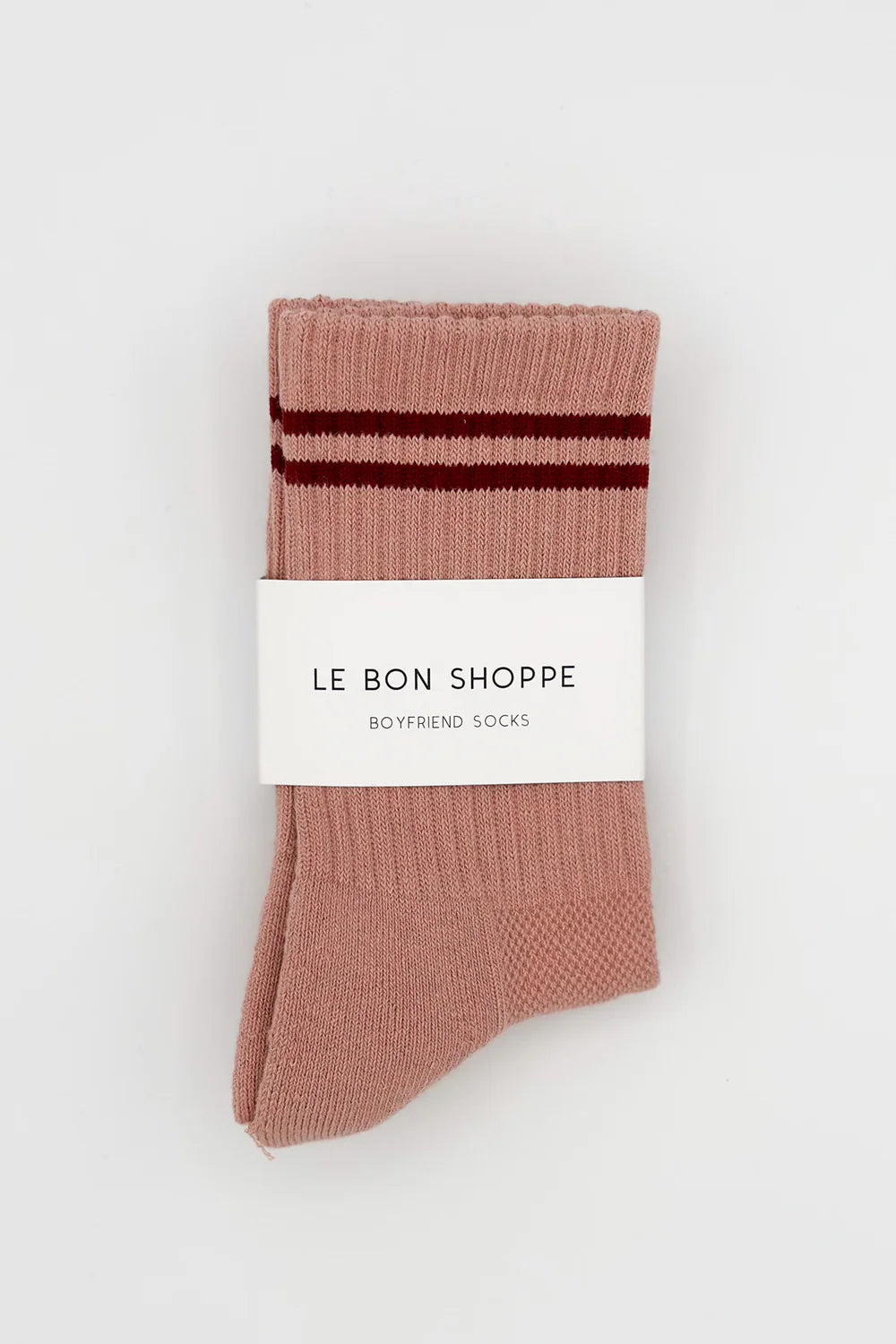 Pink socks with red stripes in white Le Bon Shoppe packaging on white background.