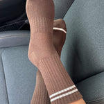 Brown socks with white stripes on a car seat