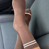 Brown socks with white stripes on a car seat
