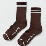 Pair of brown socks with white stripes and 'Le Bon Shoppe' branding on a light gray background