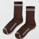 Pair of brown socks with white stripes and 'Le Bon Shoppe' branding on a light gray background