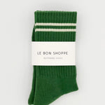 Green socks with white stripes in Le Bon Shoppe packaging.