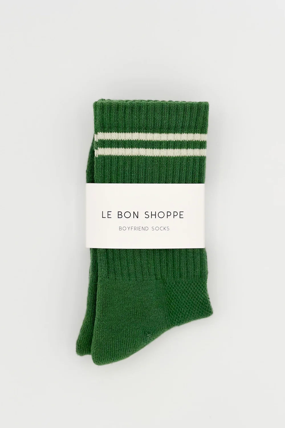 Green socks with white stripes in Le Bon Shoppe packaging.