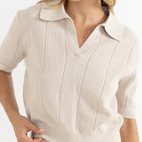 Woman wearing a beige ribbed dress with a belt on a white background