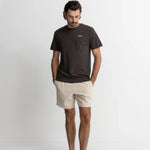 Man wearing a dark t-shirt and beige shorts on a white background