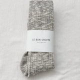 Pair of gray socks with a white label on a light gray background
