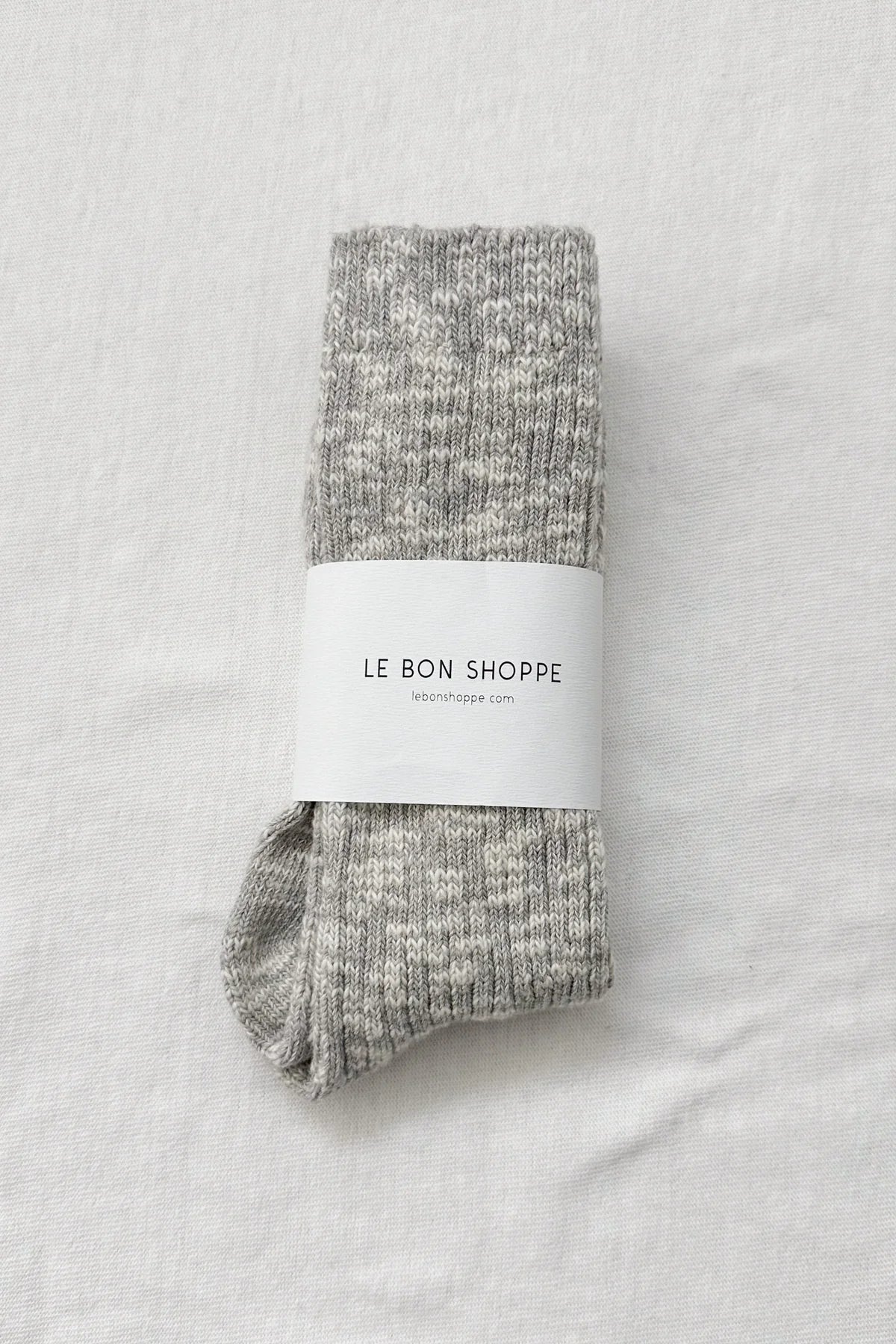 Pair of gray socks with a white label on a light gray background