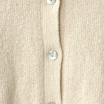 Close-up of a beige cardigan with button details