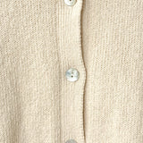 Close-up of a beige cardigan with button details