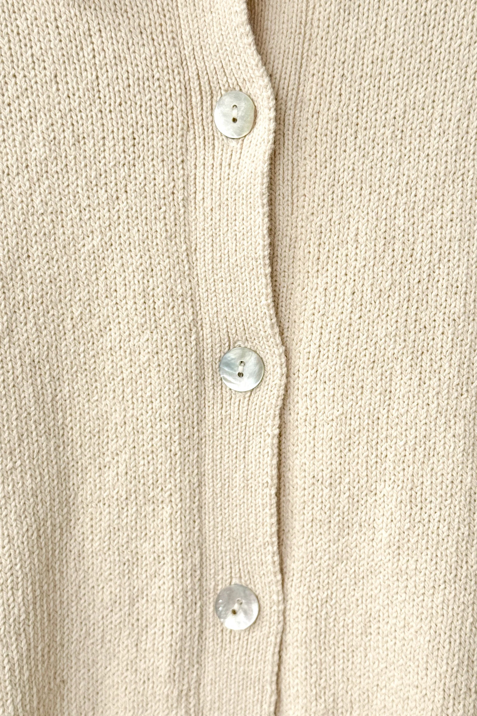 Close-up of a beige cardigan with button details