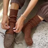 Person wearing brown ribbed socks and moccasins on a textured surface