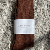 Brown socks with a white label on a textured gray surface