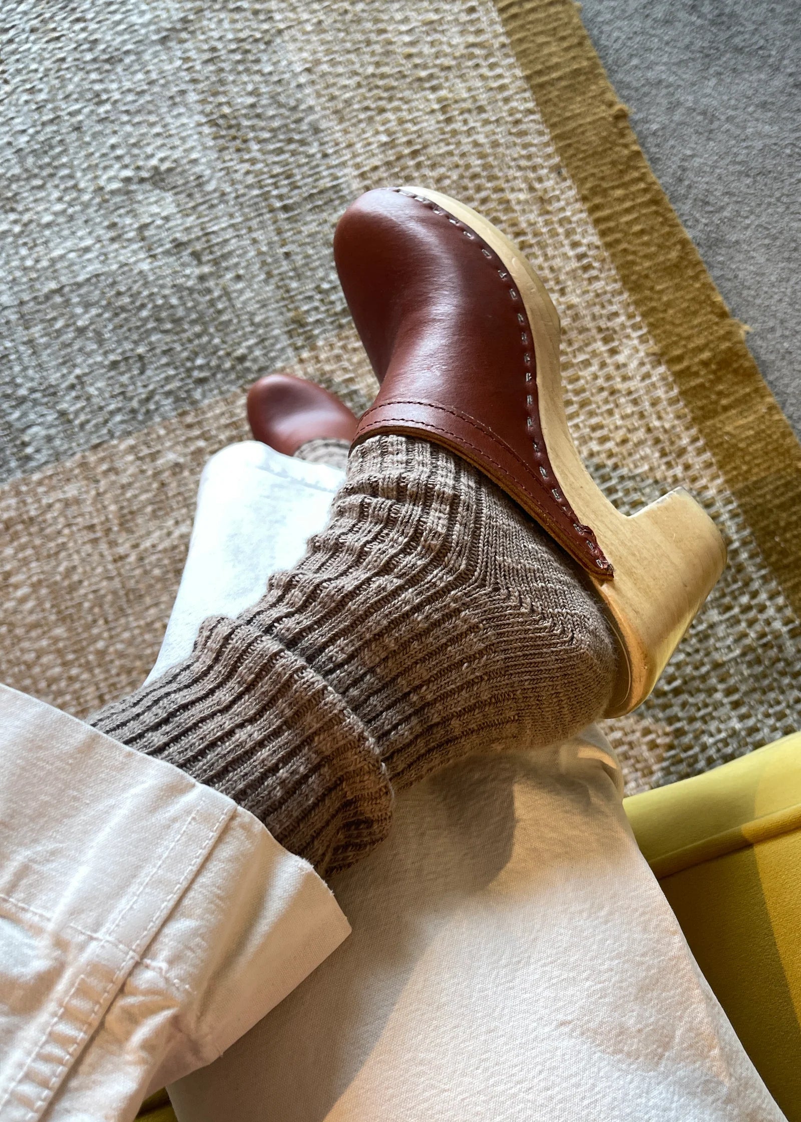 Brown leather shoes and socks on a textured floor