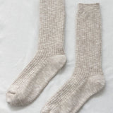Pair of beige socks on a light gray background