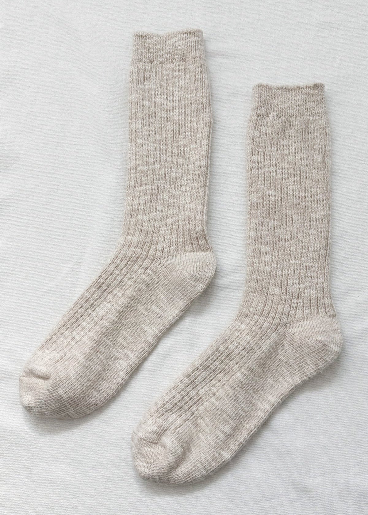 Pair of beige socks on a light gray background