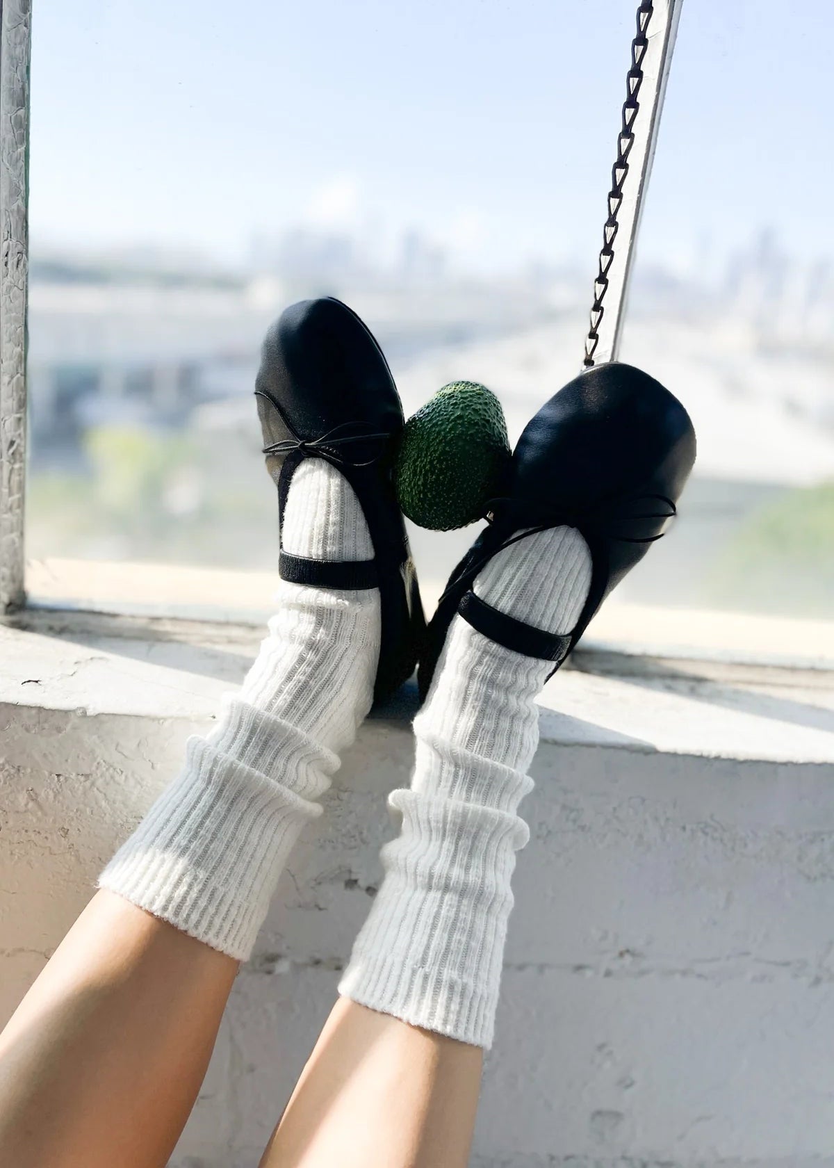 Person wearing black shoes and white socks on a swing with a blurred background